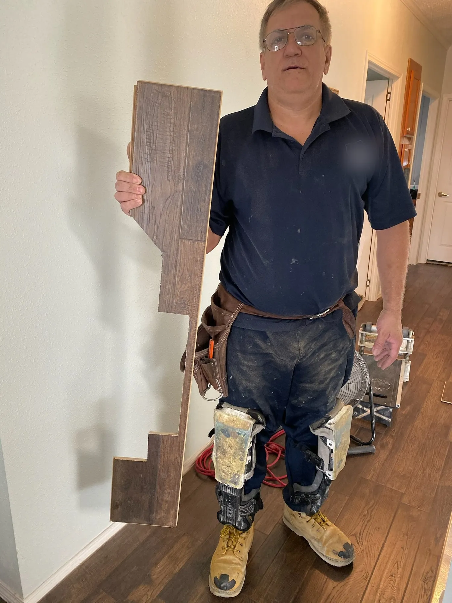 Sandro Rauen holding vinyl planks on a job site
