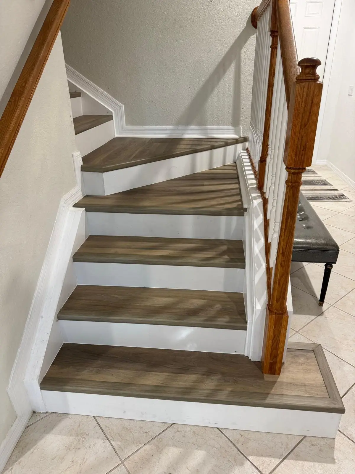 After: Painted stairs with carpet pads, rebuilt with vinyl plank treads and white risers